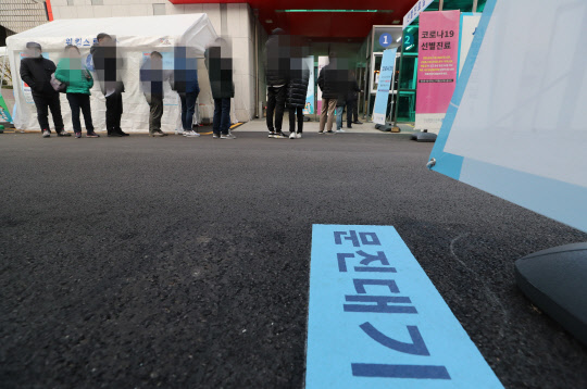 27일 오전 서울 중구 국립중앙의료원 선별진료소 앞이 검사를 받으려는 시민들로 붐비고 있다. [연합뉴스]